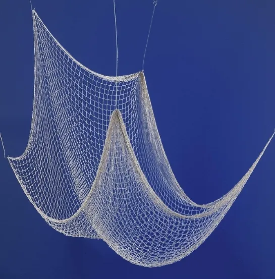 Red de pesca colgada sobre fondo azul, representando la recuperación de redes abandonadas en el océano para su transformación en moquetas por la empresa Interface