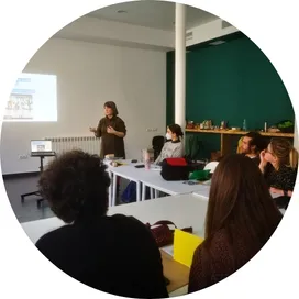 Formadora de Go Zero Waste impartiendo una sesión de formación en sostenibilidad en las oficinas de una empresa, con participantes atentos y materiales sobre las mesas