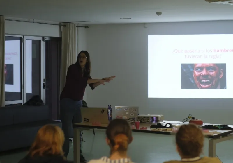 Magda Cebrián, co-fundadora de Go Zero Waste, impartiendo una formación presencial en sostenibilidad con proyección y participantes atentos