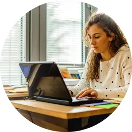 Mujer joven realizando una formación online en sostenibilidad desde su escritorio con un portátil, representando el formato e-learning de los cursos de economía circular de Go Zero Waste