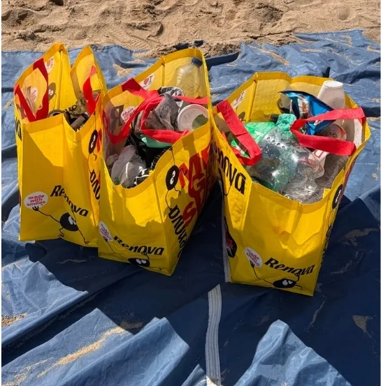 Tres bolsas amarillas llenas de residuos recogidos durante una actividad de limpieza de playa corporativa, una de las seis propuestas de team building sostenible de Go Zero Waste