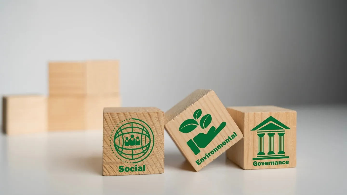 Tres bloques de madera con los iconos y términos Social, Environmental y Governance, representando los tres pilares de los criterios ESG en sostenibilidad empresarial