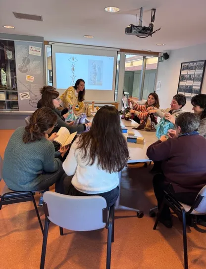 Equipo participando en un taller práctico de economía circular con materiales reutilizables y proyección, ilustrando el formato presencial de la formación en sostenibilidad de Go Zero Waste