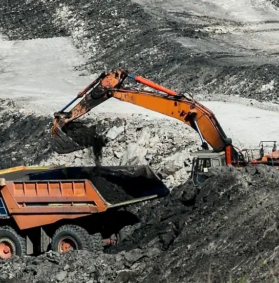 Excavadora cargando material en una mina a cielo abierto, ilustrando la extracción masiva de recursos naturales y la presión sobre las empresas para reportar su impacto ambiental bajo el estándar VSME