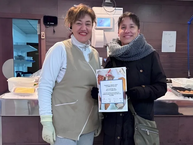 Ganadora de la campaña recibiendo su tarjeta regalo en el comercio local que ha elegido, junto a la comerciante